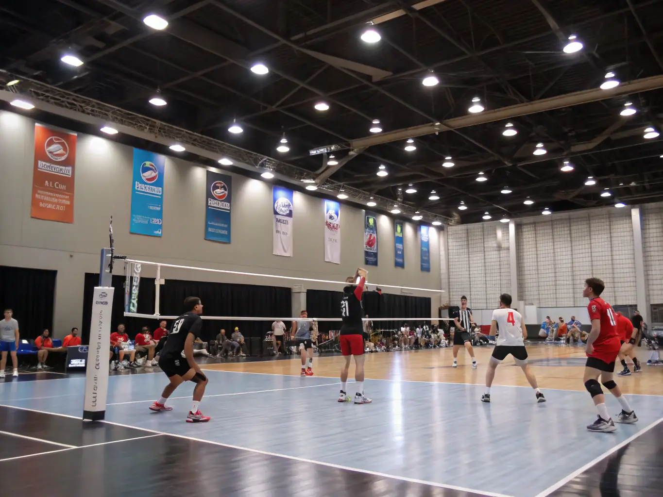An action shot of a volleyball game in progress, capturing the energy and teamwork involved in sports activities. The setting is a well-lit gymnasium with players in motion.